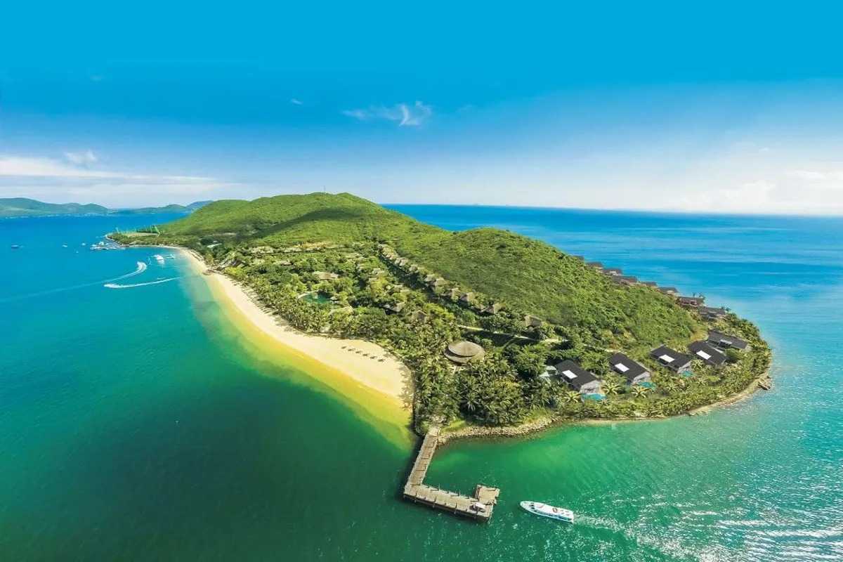 Aerial photo of Hon Mun Island showing beachfront villas and crystal-clear waters along a golden beach.