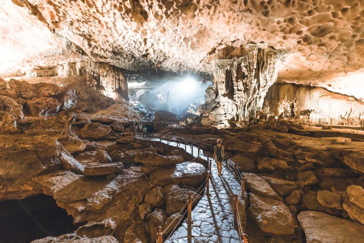 Dramatic blue and orange lighting highlighting textures of the cave walls inside Sung Sot Cave Halong Bay