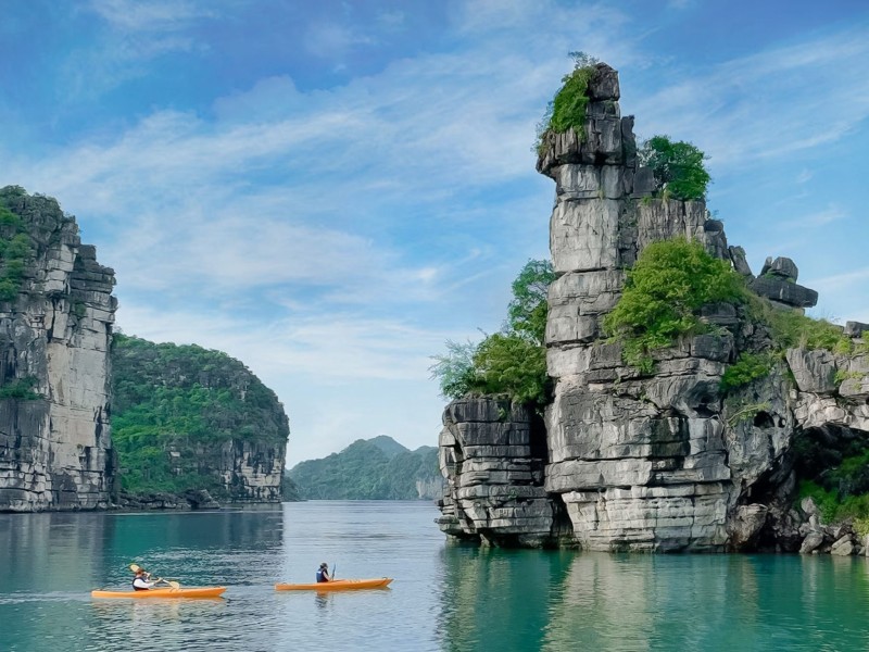 Kayakers Exploring Xep Islet in Halong Bay Kayakers paddling around Xep Islet in Halong Bay, surrounded by towering limestone formations