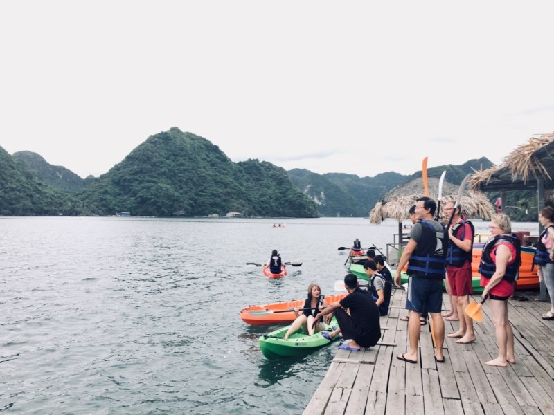 Kayaking Adventures in Tra Bau Visitors preparing for kayaking at Tra Bau with scenic views of Lan Ha Bay’s limestone mountains.