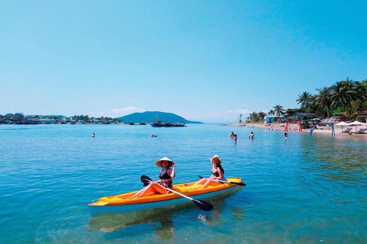 Kayaking at Robinson Beach Nha Trang Visitors kayaking on the calm waters of Robinson Beach Nha Trang surrounded by lush hills and clear skies