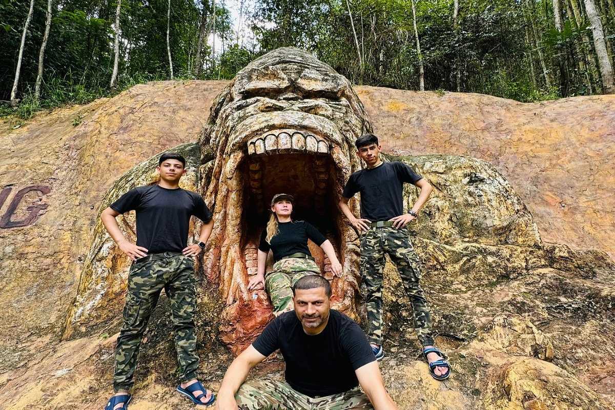 Group of tourists posing in front of Kong Forest entrance rock sculpture at Hon Ba Nature Reserve