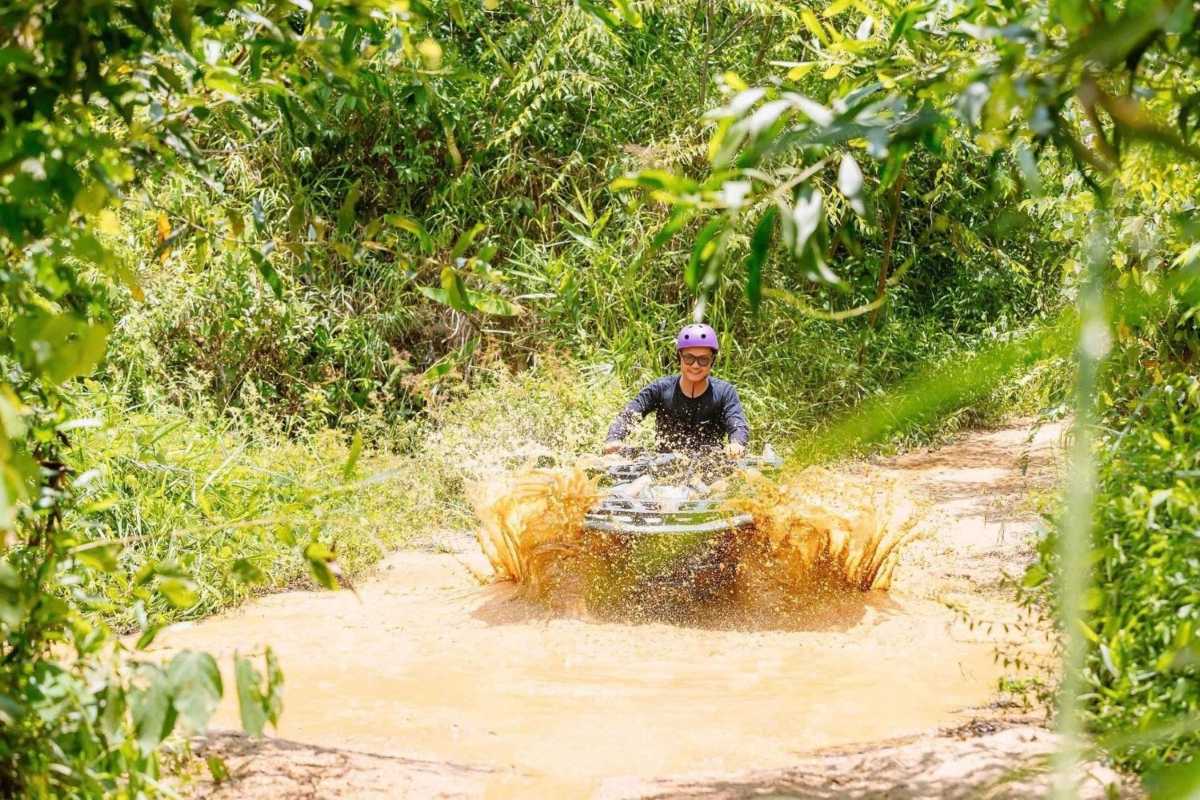 Large group posing happily in front of Kong Forest entrance with ATV in Hon Ba Nature Reserve