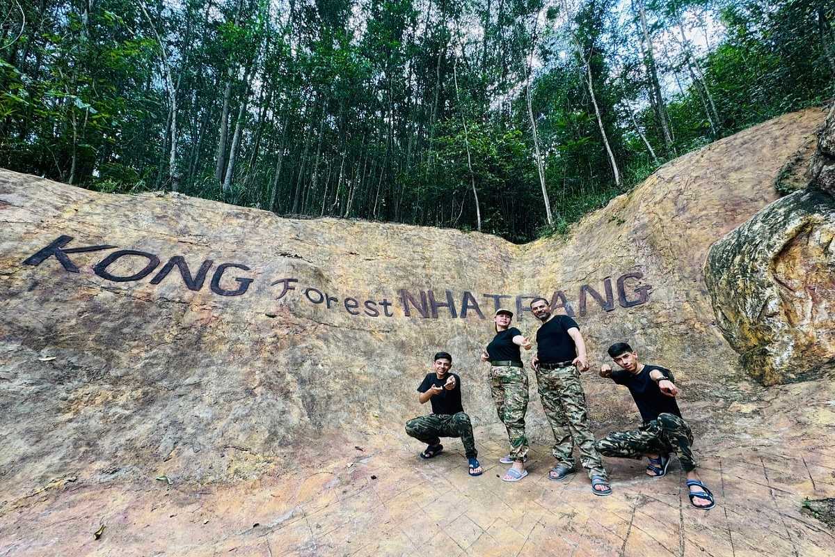 Trekker walking along lush forest trail surrounded by dense greenery in Kong Forest at Hon Ba Nature Reserve