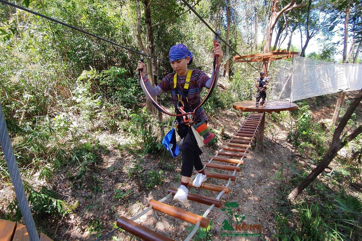 Visitor crossing rope bridge on trekking trail inside Kong Forest at Hon Ba Nature Reserve