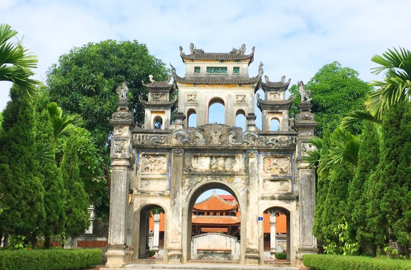 Le Mat Snake Village Gate Ancient stone gate of Le Mat Snake Village, adorned with intricate carvings and flanked by lush greenery, symbolizing the historical significance of the village.