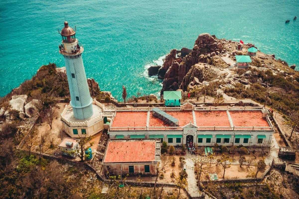 Lighthouse at Dai Lanh Beach overlooking the sea Historic white lighthouse standing on rocky hill overlooking blue sea at Dai Lanh Beach, Nha Trang