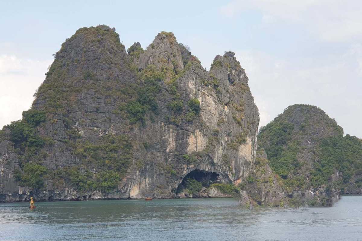 Limestone cliffs surrounding the entrance to Drum Cave Halong Bay, emphasizing its geological significance.