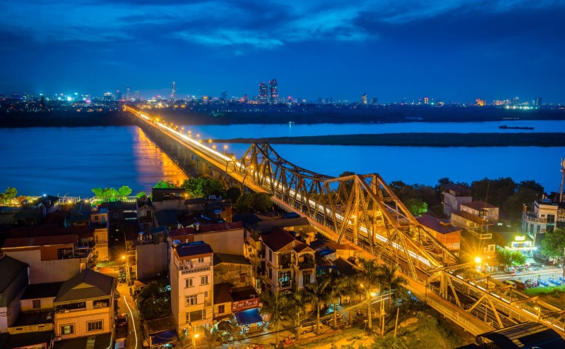 Long Bien Bridge Illuminated at Night A nighttime aerial view of Long Bien Bridge, illuminated and stretching across the Red River in Hanoi, Vietnam.
