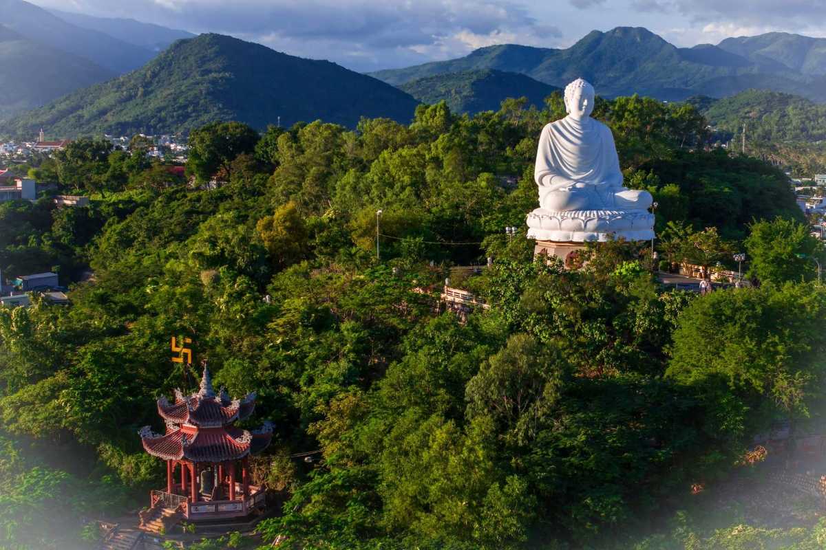 Buddha and Pavilion at Sunset Long Son Pagoda's Buddha and red-roofed pavilion captured during sunset with distant mountains.