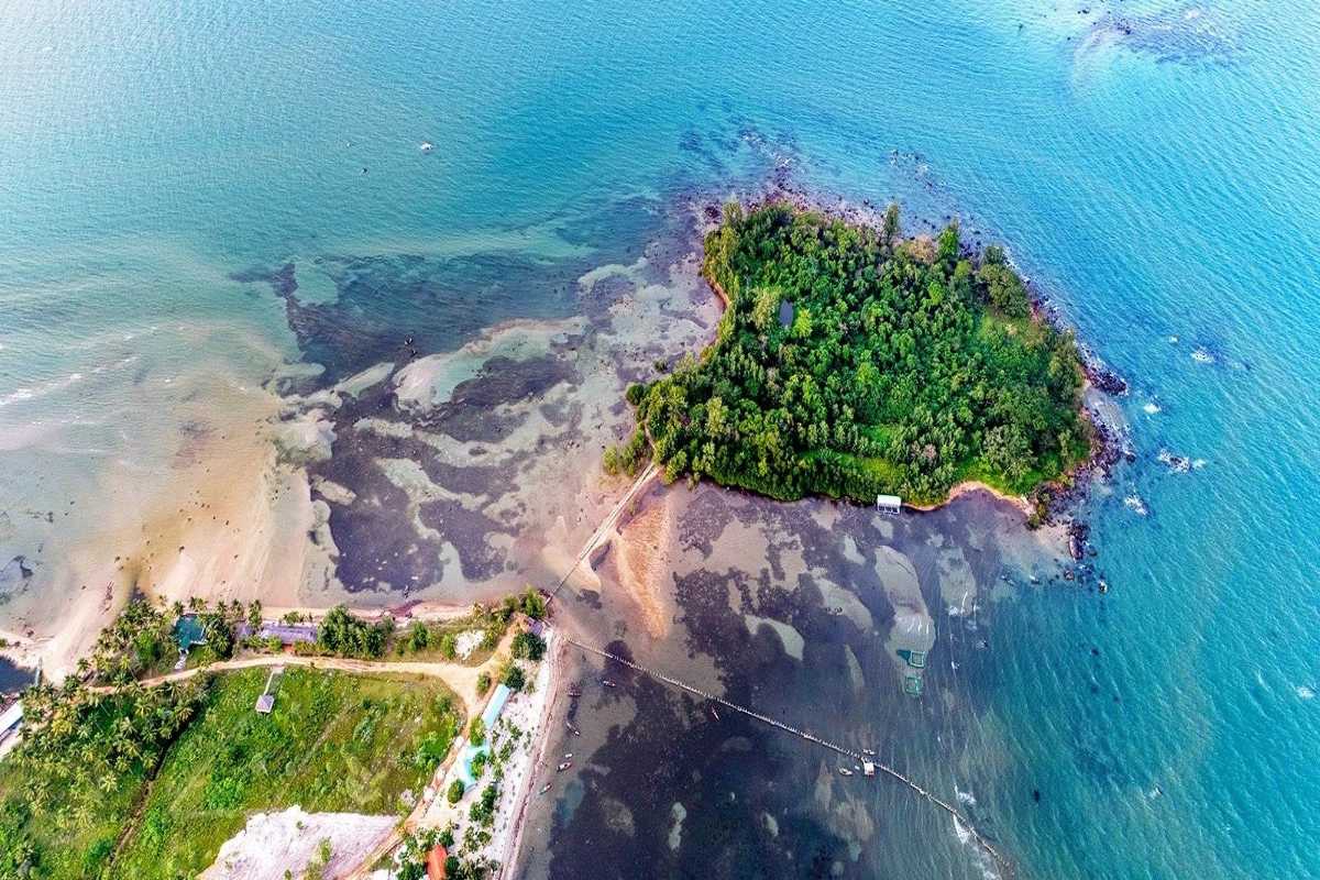 Aerial shot of walkway connecting mainland to Hon Mot Island during low tide