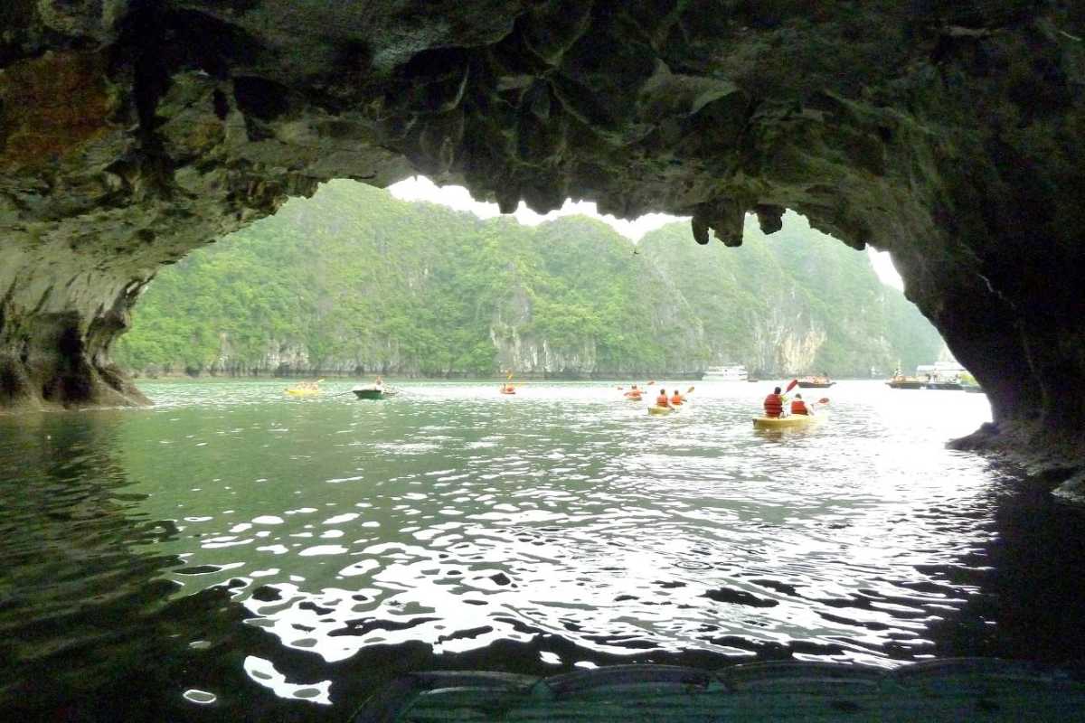 Entrance of limestone cave with scenic view of islands in Luon Cave, Halong Bay