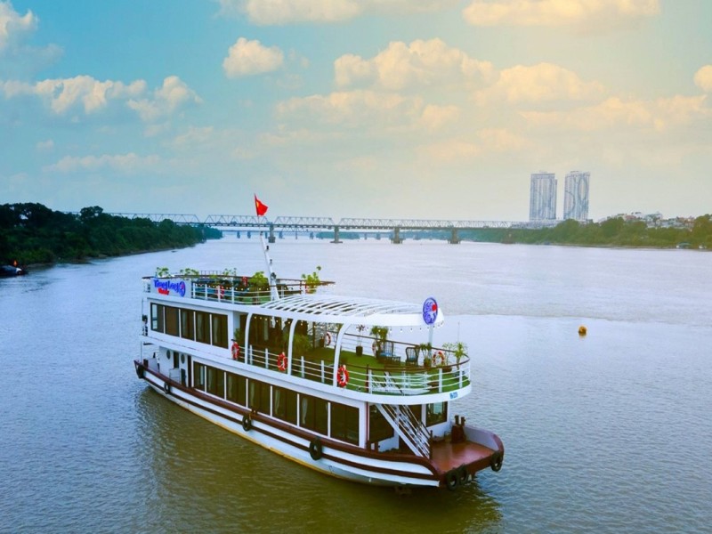Luxury Cruise on the Red River A luxury cruise ship sailing along the Red River, offering scenic views of Hanoi's landscapes and modern bridges.