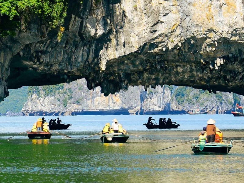 Magnificent Views of Ha Long Bay from Dark and Light Caves A magnificent view of Ha Long Bay from within Dark and Light Caves, showing limestone cliffs and serene waters.