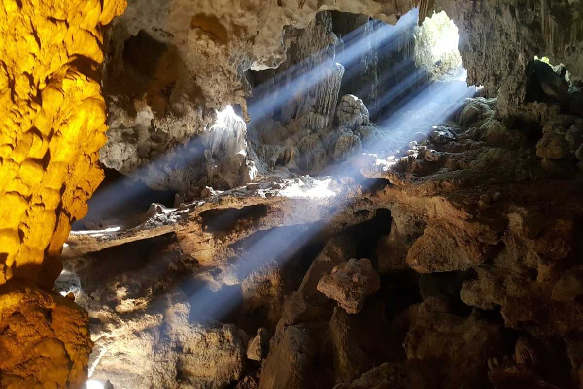 Colorful rock formations inside Me Cung Cave Halong Bay with dynamic lighting effects enhancing textures.