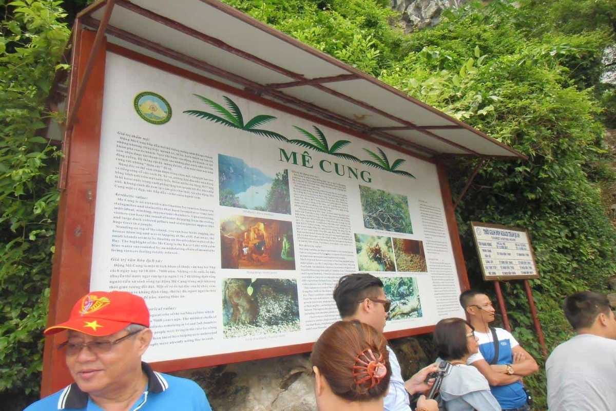 Entrance signboard at Me Cung Cave Halong Bay with visitors gathering before the cave tour