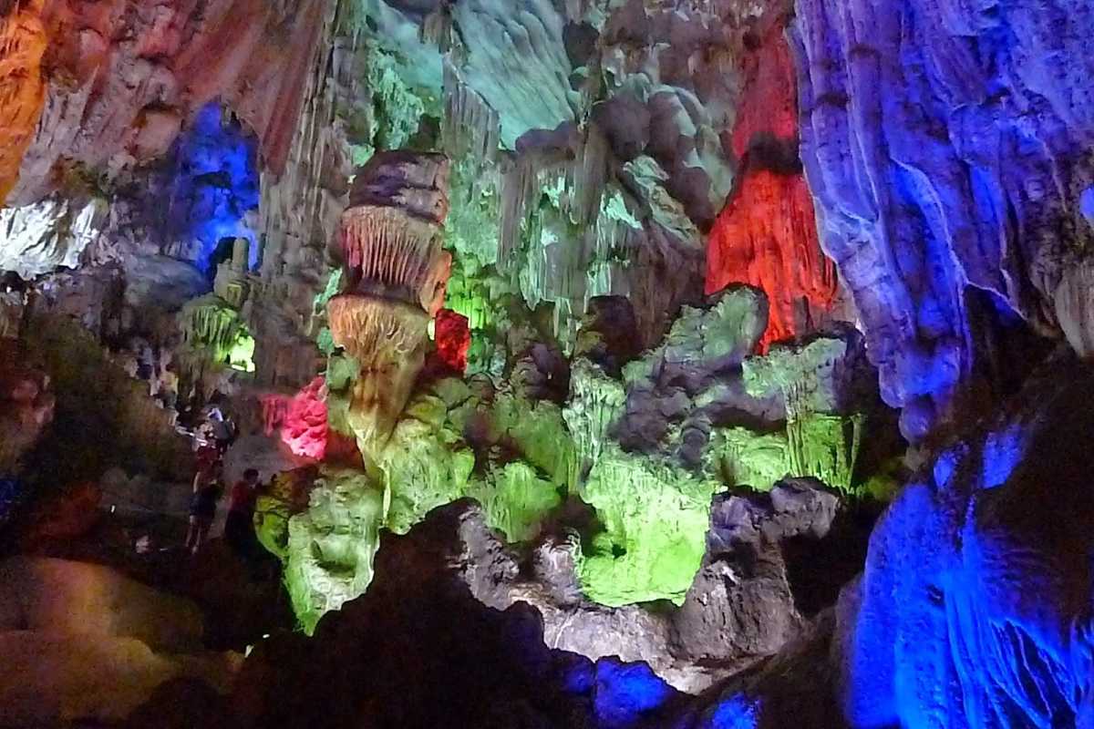 Vibrant illuminated interiors of Me Cung Cave Halong Bay showcasing colorful stalactites and stalagmites.
