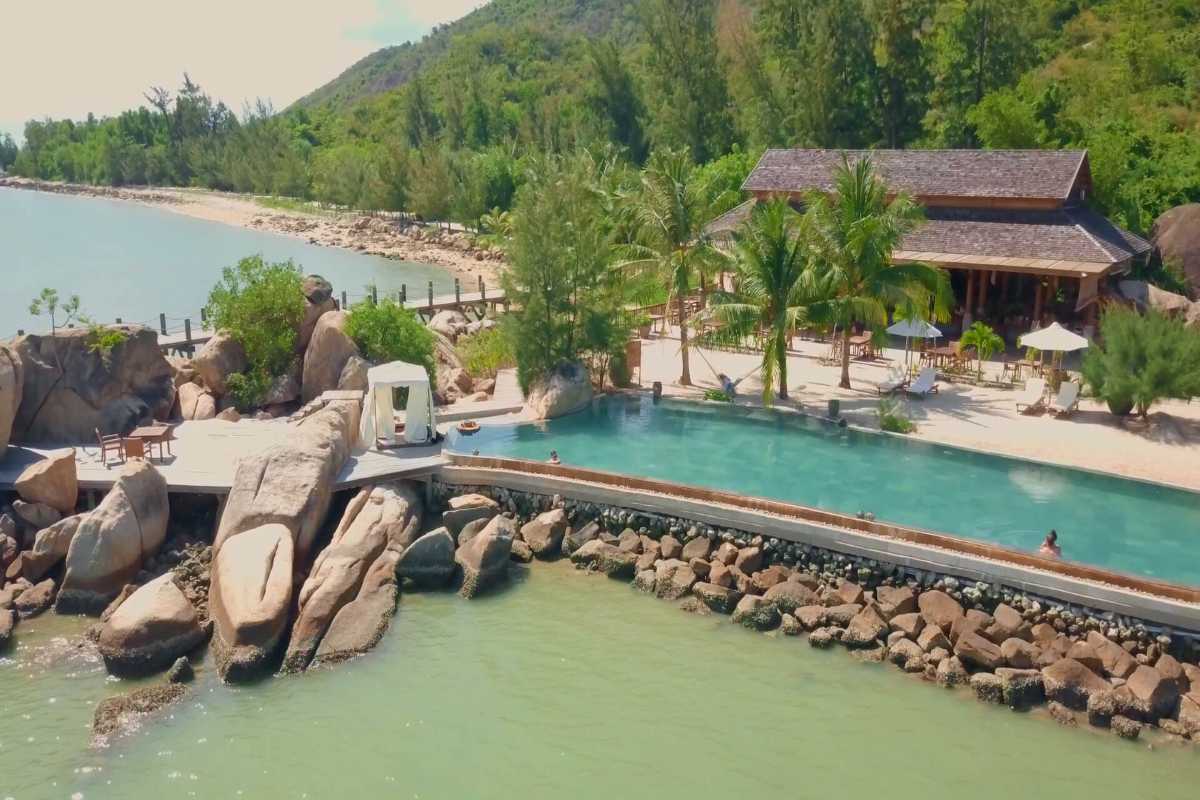 Ninh Van Bay beach resort pool Private resort pool next to the beach with palm trees and lounge seating in Ninh Van Bay.
