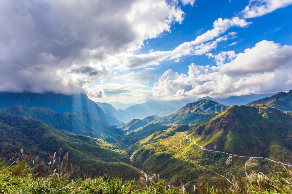 Scenic view of O Quy Ho Pass with mountainous landscape under a dramatic sky