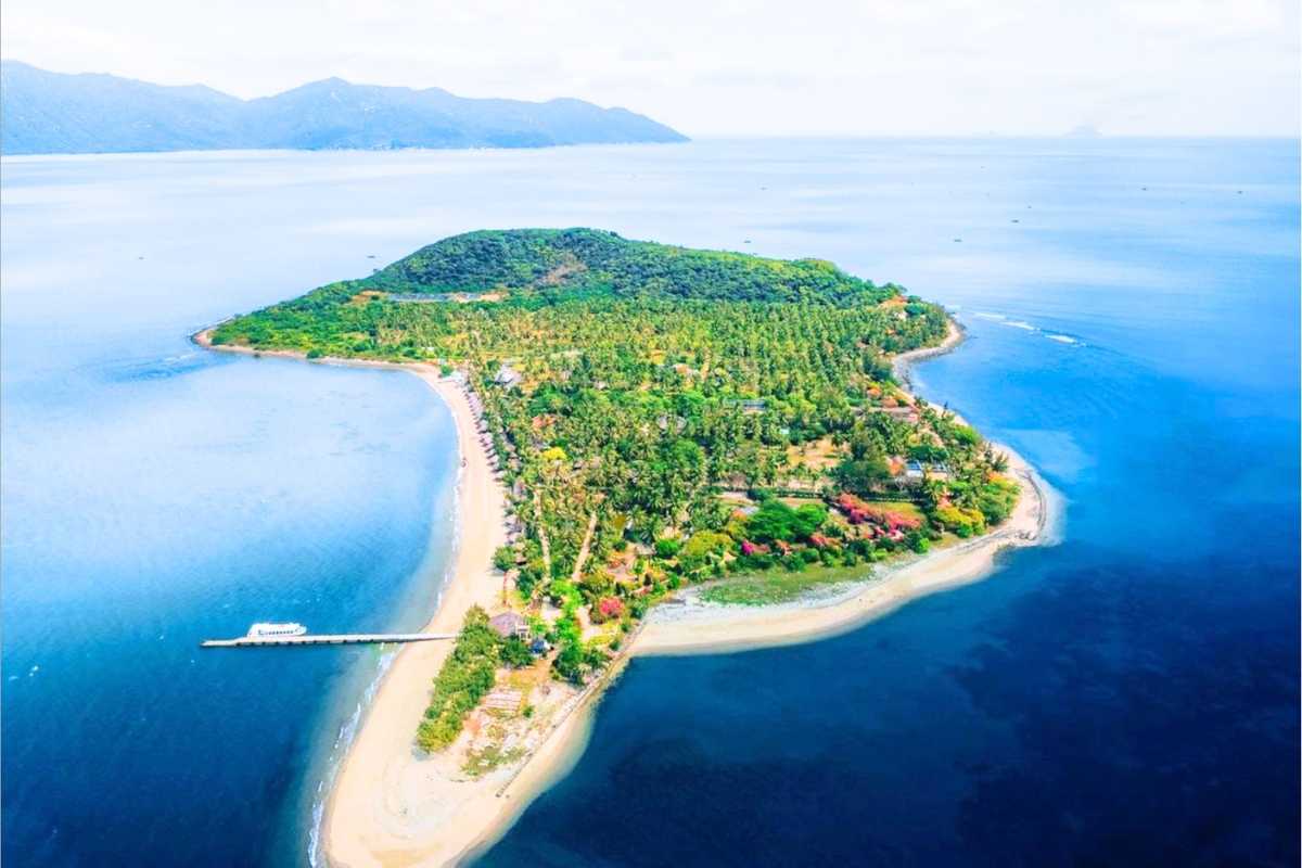 Aerial view of Orchid Stream Island showing green forests and surrounding blue sea in Nha Trang