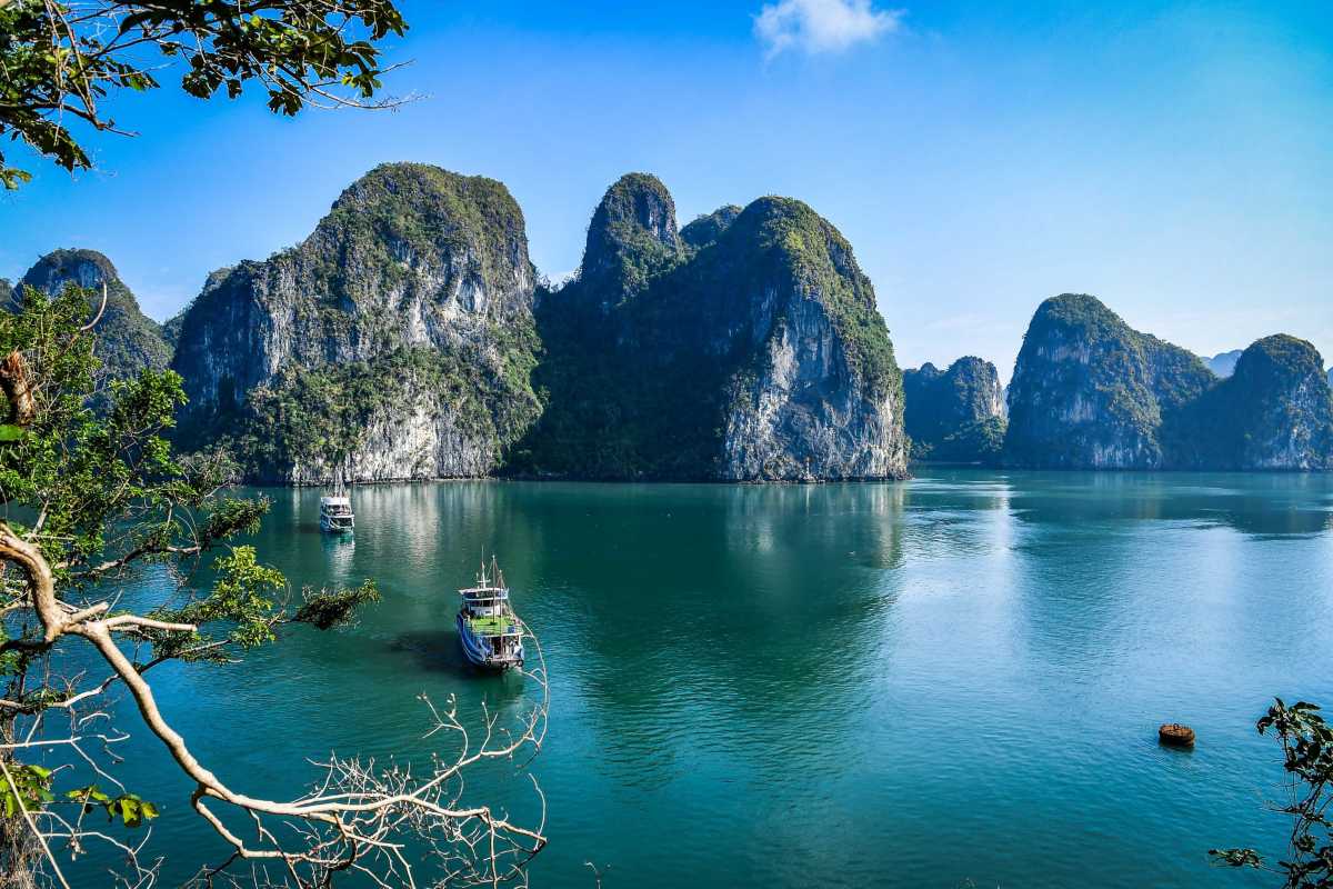View of boats and karst islands on Halong Bay seen from inside Drum Cave, offering visitors a peaceful retreat.