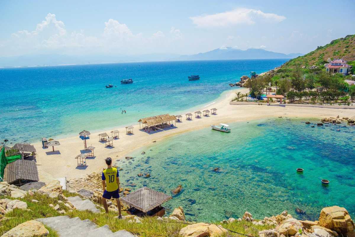 Panoramic View from Yen Island Hill Traveler overlooks the turquoise bay and sandy stretch of Yen Island from a grassy hill.