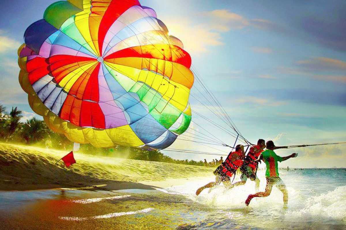 Colorful parasail launching from the beach near Hon Mot Island under clear skies