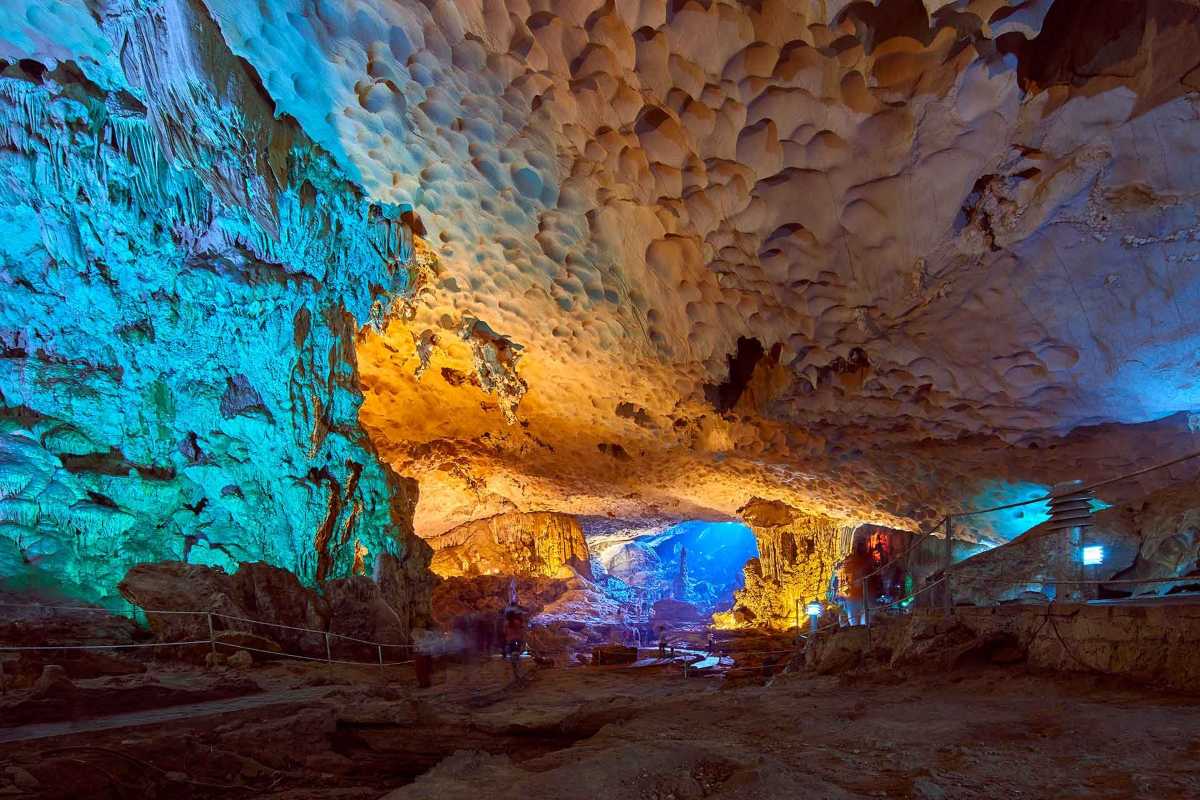 Curved stone pathway winding through rocky terrain inside Sung Sot Cave Halong Bay illuminated by soft lighting