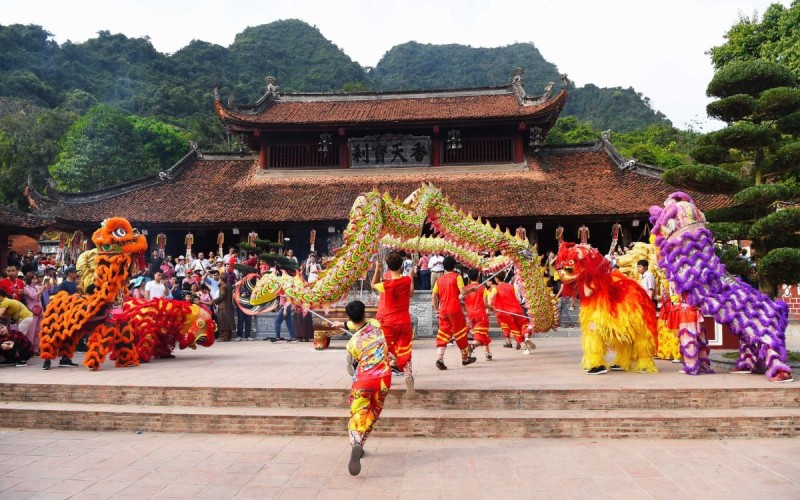 Perfume Pagoda Festival – Celebrating Culture and Spirituality in Hanoi A vibrant dragon dance performance during the Perfume Pagoda Festival, with a backdrop of Thien Tru Pagoda in Hanoi.