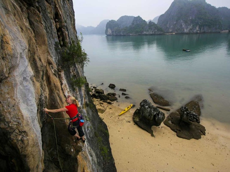 Rock Climbing on Tiger Beach, Cat Ba Island Climber scaling a rock face on Tiger Beach, Cat Ba Island