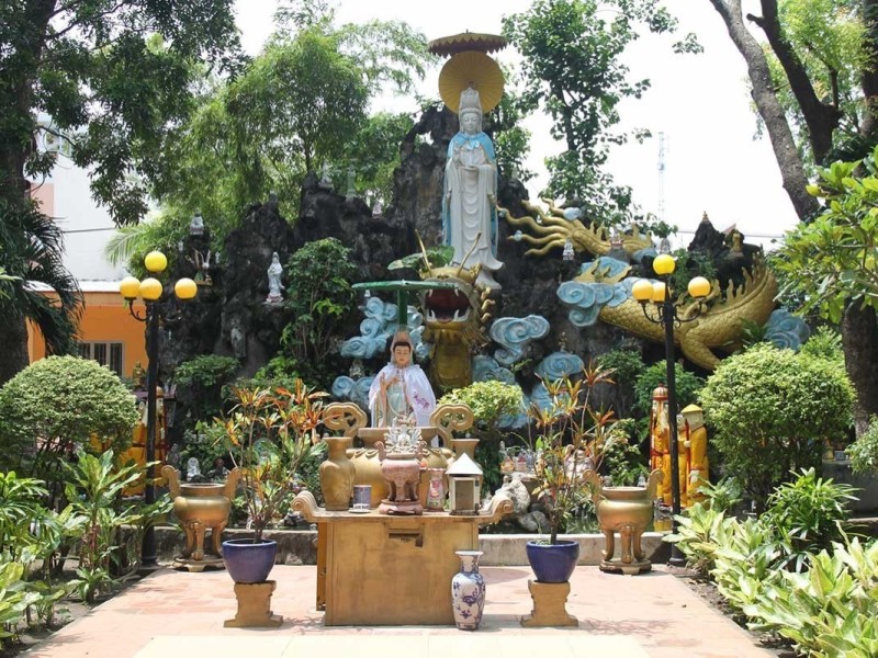 Sacred Bodhi Tree and Avalokiteshvara Statue Bodhi tree and Avalokiteshvara statue at Giac Lam Pagoda in a lush garden setting