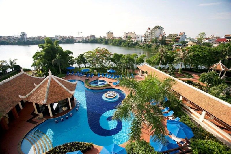 Sheraton Hotel Overlooking West Lake in Hanoi Sheraton Hotel Hanoi West Lake featuring a swimming pool with views of the lake and lush surroundings, offering a luxurious stay.