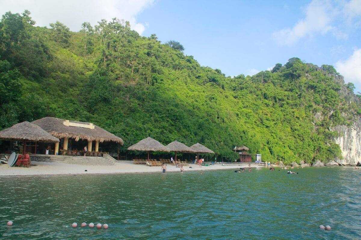 Soi Sim Island Halong Bay wooden pier extending along the rocky coastline with tourists walking