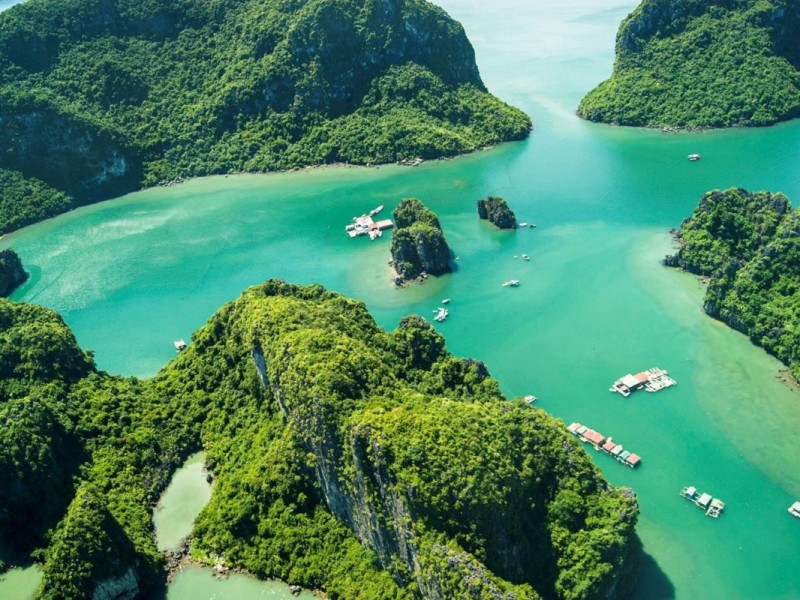 Stunning green bays and islets near Cong Do Island An aerial view of the green bays and limestone islets near Cong Do Island, showcasing the natural beauty of Bai Tu Long Bay.