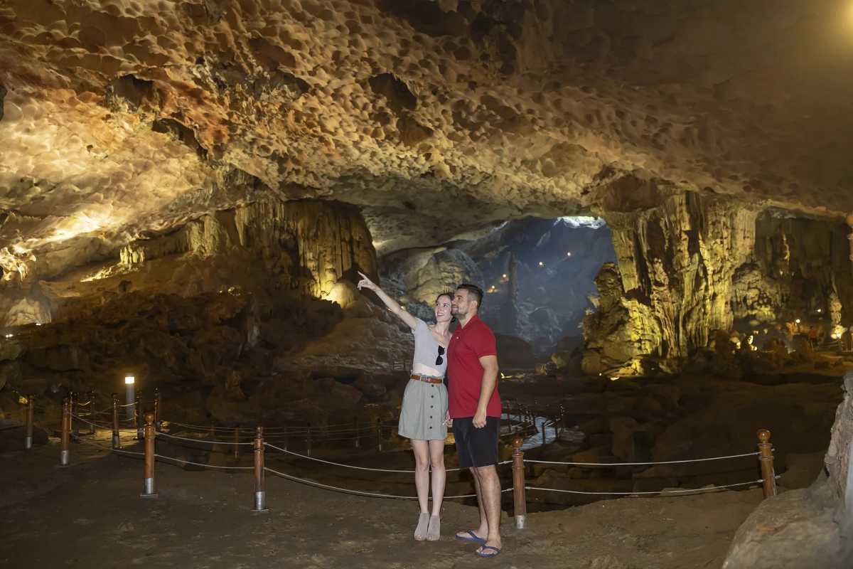 Tourists enjoying the spacious interior of Sung Sot Cave Halong Bay, with scenic views and well-maintained paths.