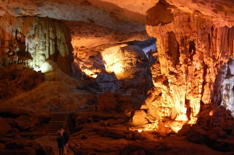 Sung Sot Cave Illuminated in Halong Bay Interior of Sung Sot Cave, brightly illuminated with orange and yellow lights highlighting the stalactites and stalagmites.