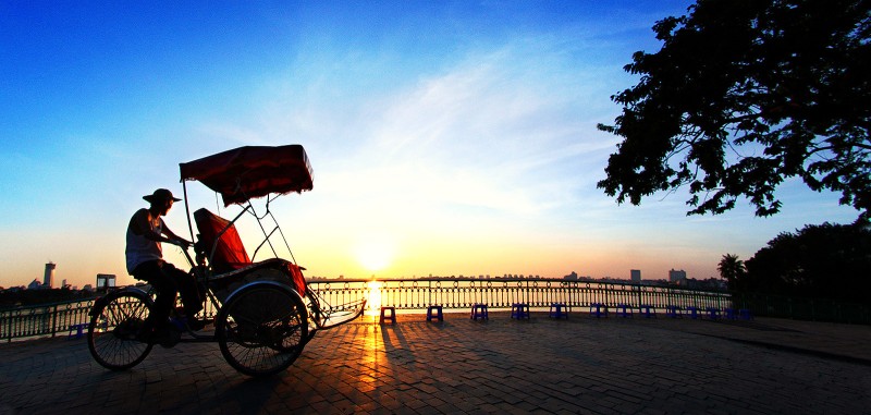 Sunset Cyclo Ride to Tran Quoc Pagoda Cyclo driver taking a sunset ride toward Tran Quoc Pagoda along the lakeside