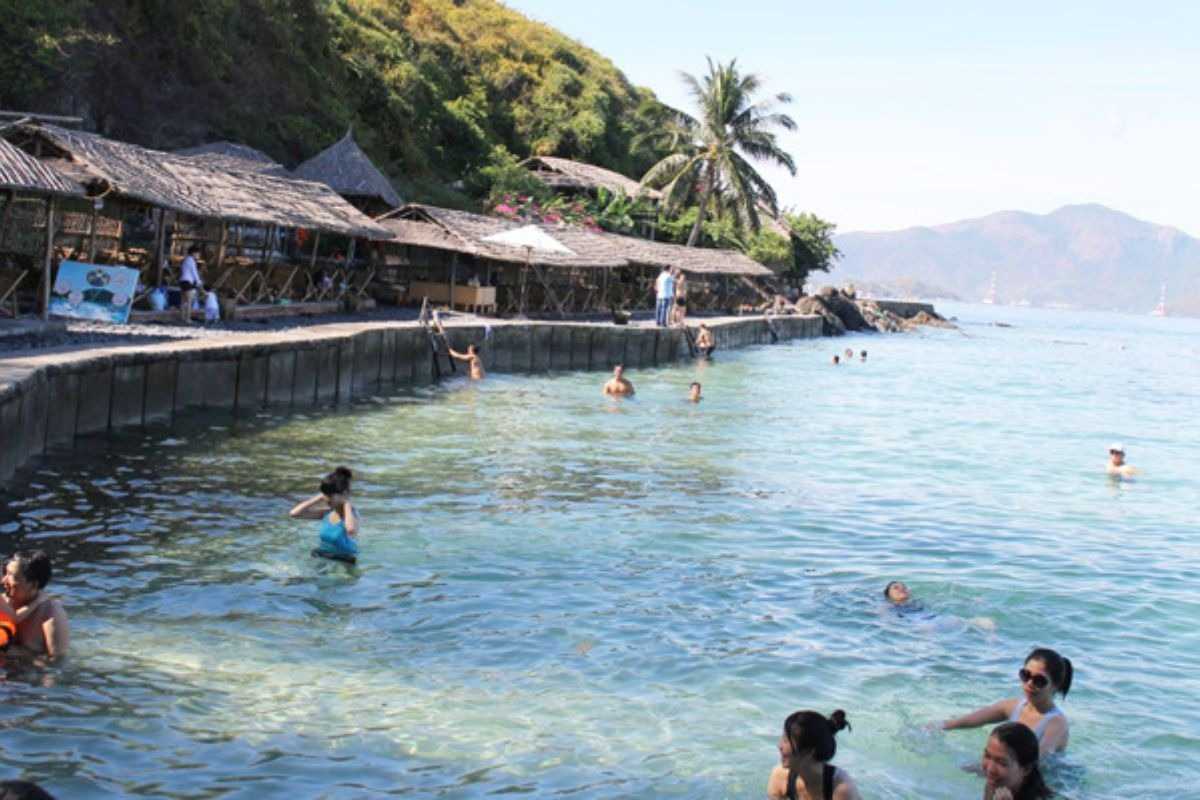 Swimming Area at Con Sẻ Tre Village Visitors swimming and relaxing in the clear, shallow waters near Con Sẻ Tre Village