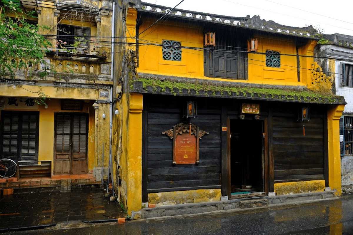 Interior view of Tan Ky Ancient House showcasing antique wooden furniture and traditional decor in Hoi An, Vietnam.