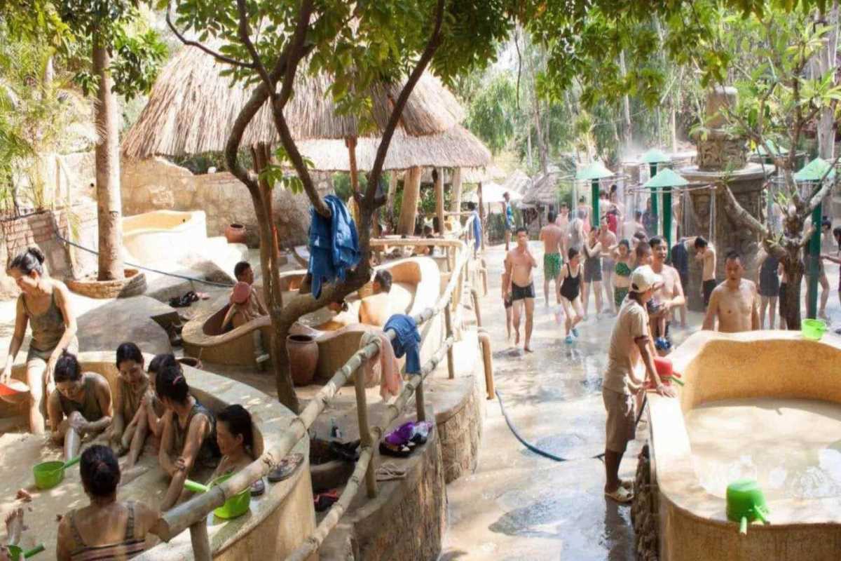 Social mud bath area at Thap Ba Groups of bathers enjoy the therapeutic mud tubs under shaded cabanas at Thap Ba Hot Springs in Nha Trang