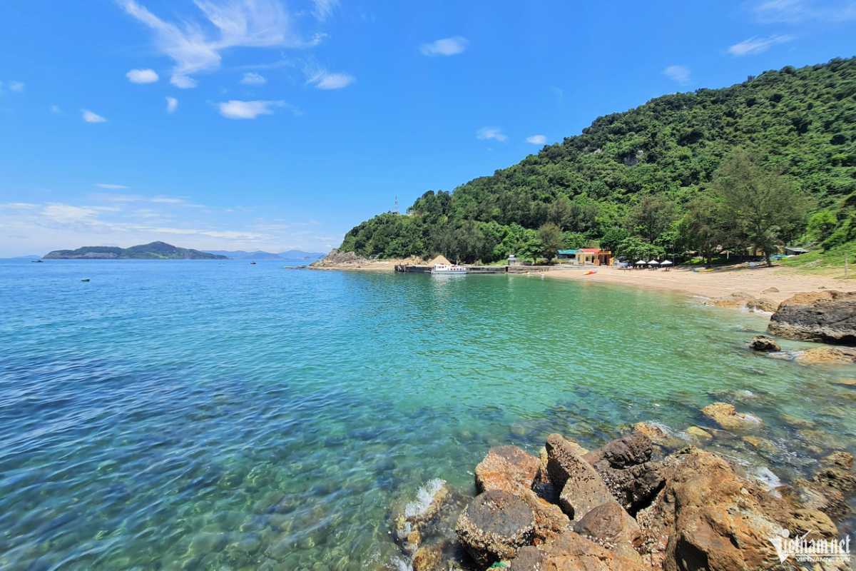 Crystal-clear beach at Thi Island Crystal-clear water gently washing over the sandy beach at Thi Island Nha Trang with forested hills in the background