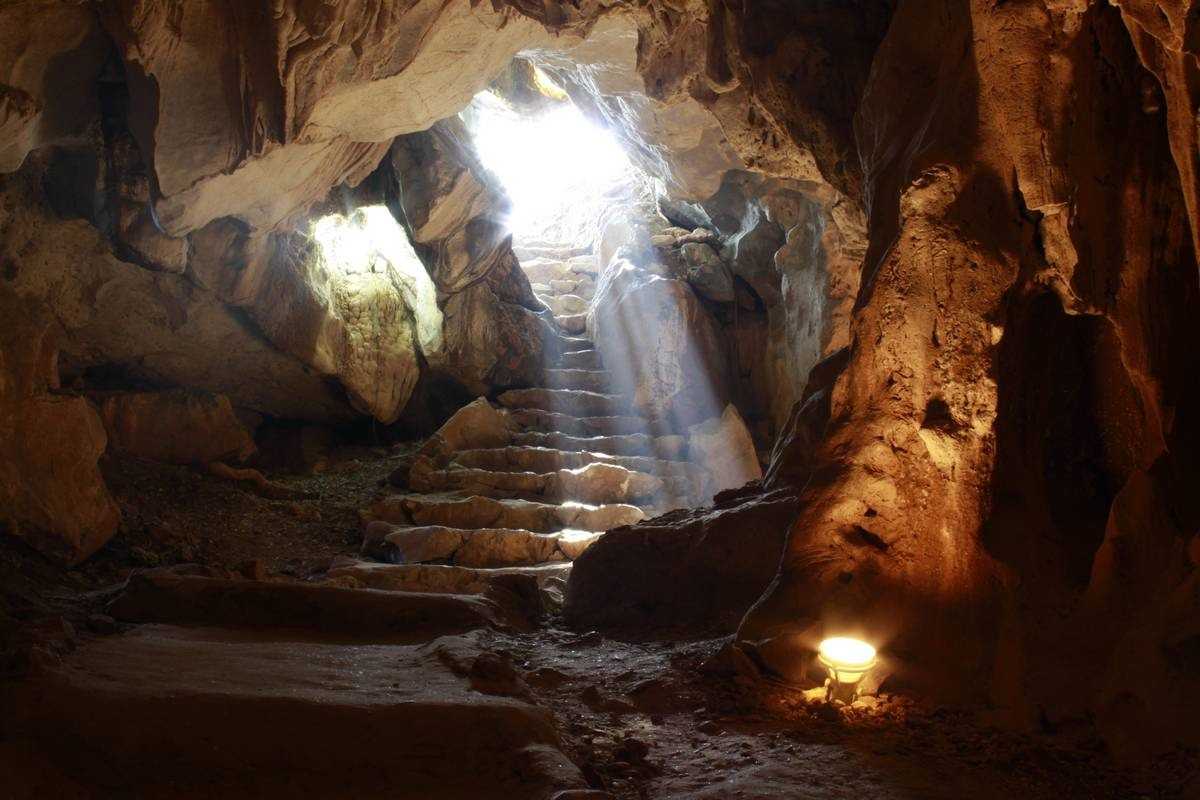 Wide chamber inside Thien Canh Son Cave brightly lit to showcase rock formations