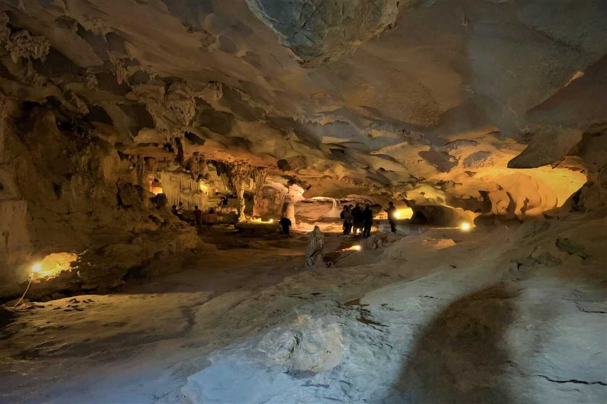 Multicolored lighting illuminating different rock formations inside Thien Canh Son Cave