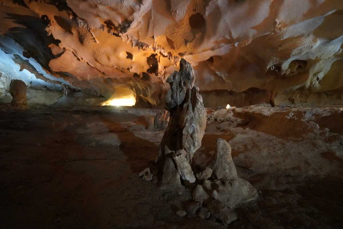Interior chamber of Thien Canh Son Cave featuring unique rock formations and dim lighting