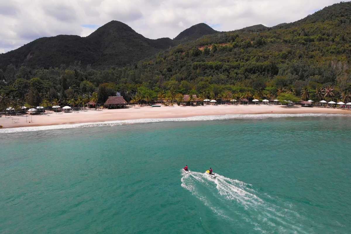 Clear turquoise waters gently meeting the sandy shore of Tien Beach, Nha Trang under a sunny sky.