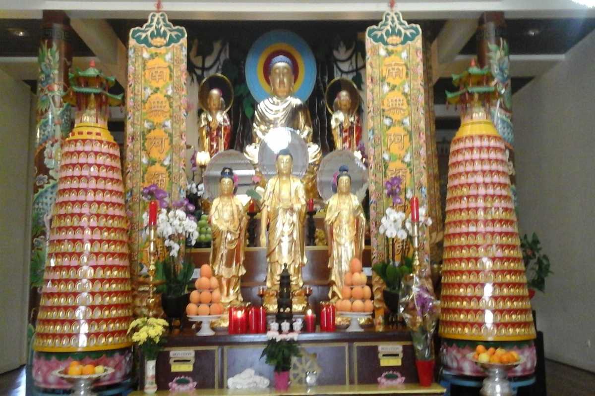 Interior of Tong Lam Lo Son Pagoda showing golden Buddha statues and colorful pillars adorned with traditional motifs