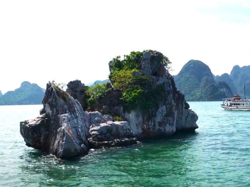 Tourist Boats Near Fighting Cocks Islet Halong Bay Tourist boats surrounding Fighting Cocks Islet in Halong Bay, offering close views of the famous rock formations.