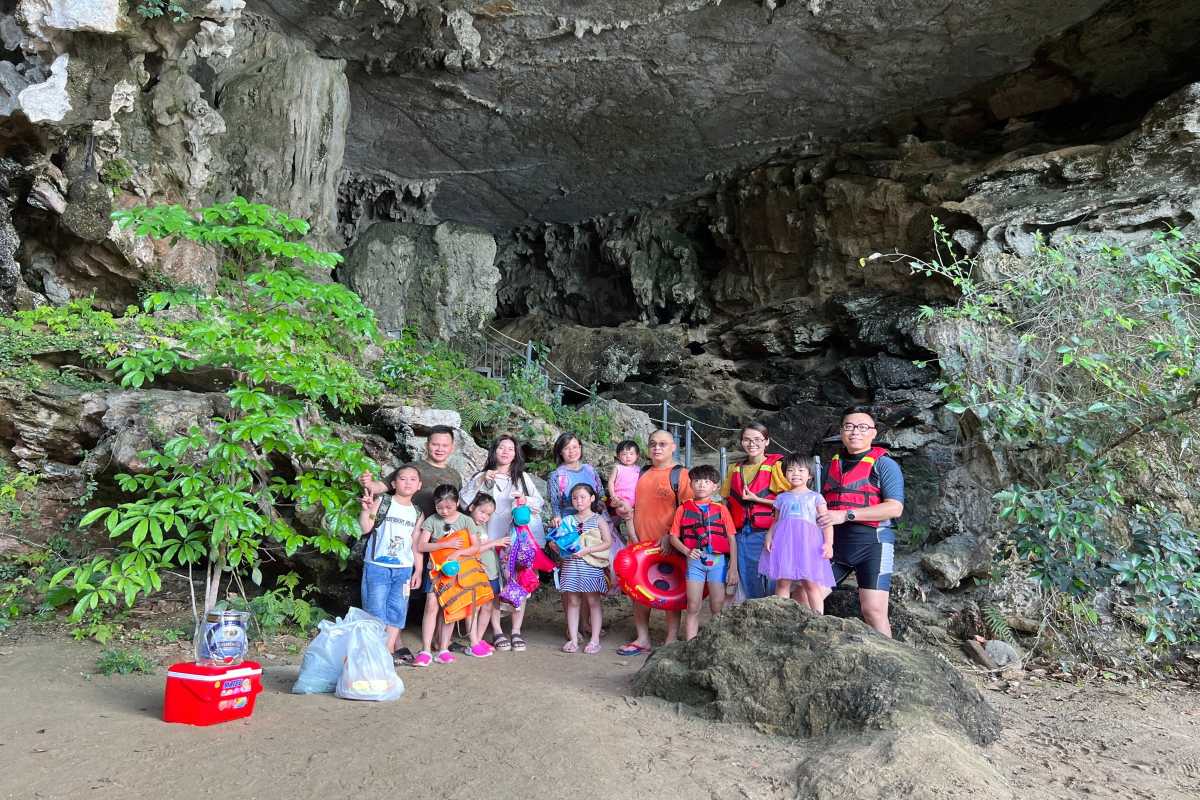 Wooden junk boat sailing near Drum Cave Halong Bay, popular for tours and cruises in the area.