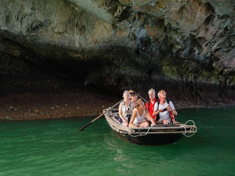 Travelers Enjoying a Bamboo Boat Ride at Dark and Light Cave Tourists enjoying a bamboo boat ride at Dark and Light Cave in Halong Bay
