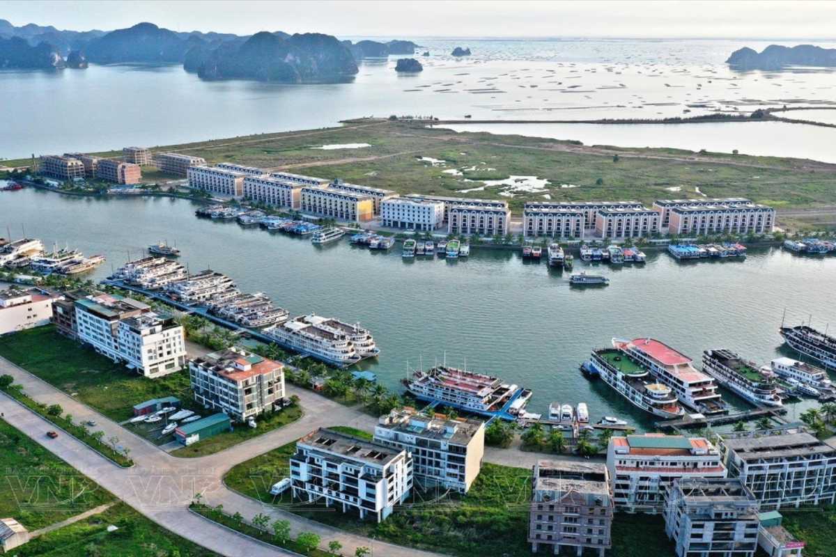 Cruise boats docked at Tuan Chau Harbor Ha Long Bay surrounded by hotels and calm waters